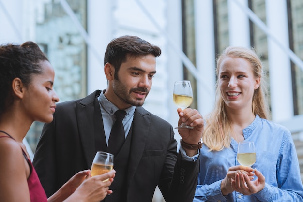 Grupa szczęśliwy młody biznes z kolegami pije szampańskiego świętowania przyjęcia sukces pracować w plenerowym