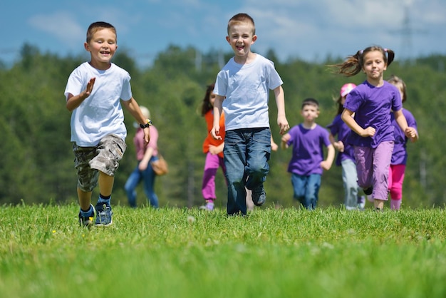 Zdjęcie grupa szczęśliwych dzieci bawi się w parku na świeżym powietrzu