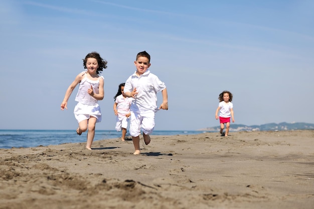 grupa szczęśliwych dzieci na plaży, które bawią się i grają w gry