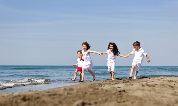 grupa szczęśliwych dzieci na plaży, które bawią się i grają w gry