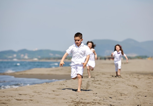 grupa szczęśliwych dzieci na plaży, które bawią się i grają w gry