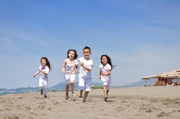 grupa szczęśliwych dzieci na plaży, które bawią się i grają w gry