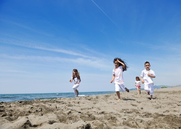 grupa szczęśliwych dzieci na plaży, które bawią się i grają w gry