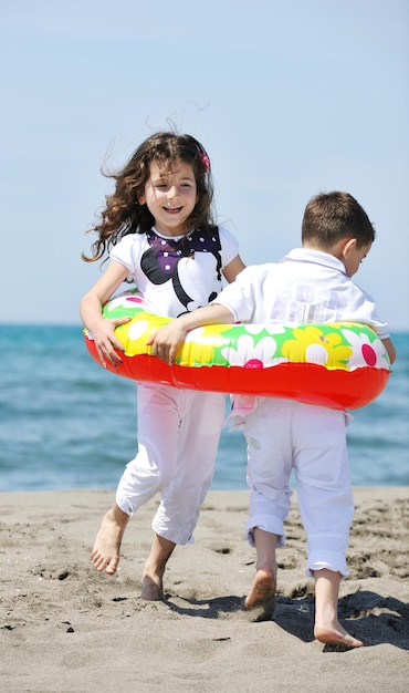 grupa szczęśliwych dzieci na plaży, które bawią się i grają w gry