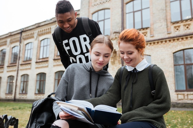 Grupa szczęśliwych młodych wieloetnicznych studentów studiujących na zewnątrz