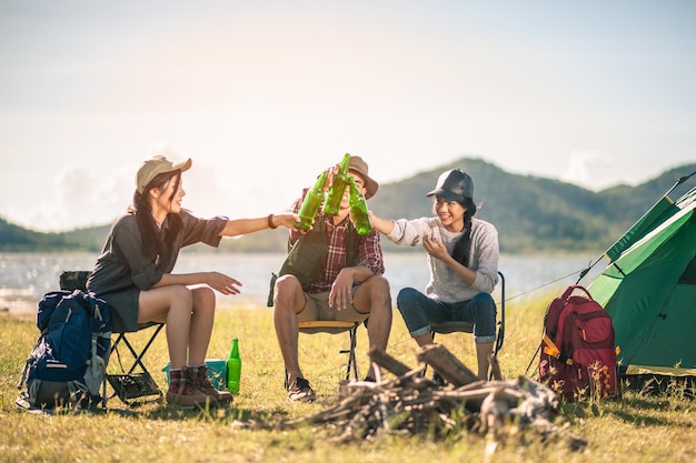 grupa turystów brzęczących butelek piwa w koncepcji camping.adventure, podróży, turystyki, przyjaźni i ludzi.