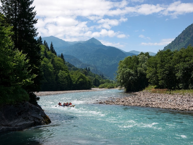 Grupa Turystów Spływa Rzeką W Dół Rzeki, Podziwiając Niesamowity Górski Krajobraz