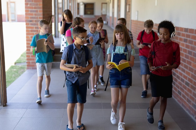 Zdjęcie grupa uczniów spacerujących korytarzem na świeżym powietrzu w szkole podstawowej