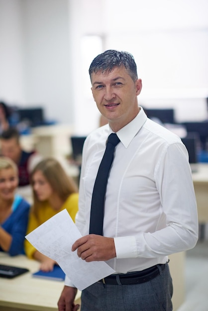 Zdjęcie grupa uczniów z nauczycielem w laboratorium komputerowym z klasy do nauki lekcji otrzymuje pomoc i wsparcie