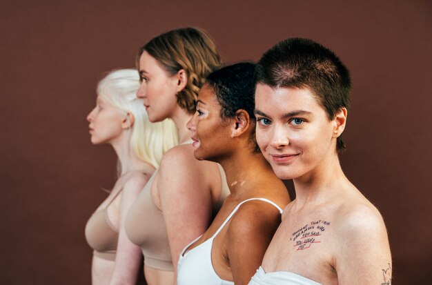 grupa wieloetnicznych kobiet o różnym rodzaju skóry pozujących razem w studio