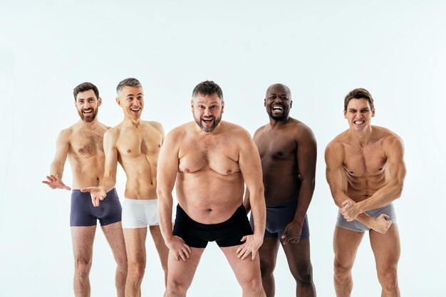 Grupa wieloetnicznych mężczyzn pozujących dla męskiej edycji ciała pozytywnego zestawu piękności. Faceci bez koszuli w różnym wieku, z ciałem w bieliźnie bokserskiej