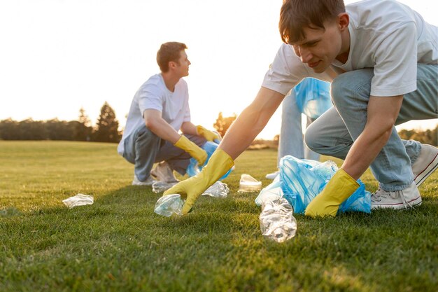 Zdjęcie grupa wielonarodowych ludzi w rękawiczkach i z workami na śmieci usunąć plastik i śmieci