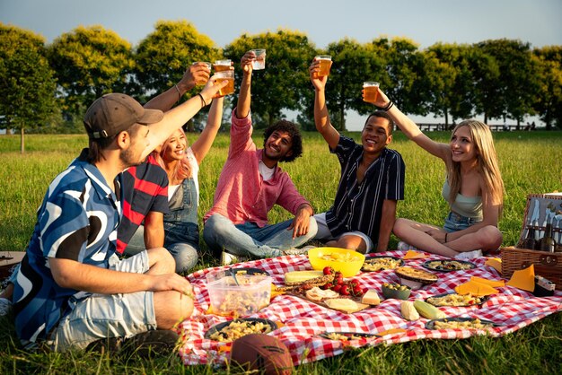 Grupa wielonarodowych nastolatków spędzających czas na zewnątrz na pikniku w parku