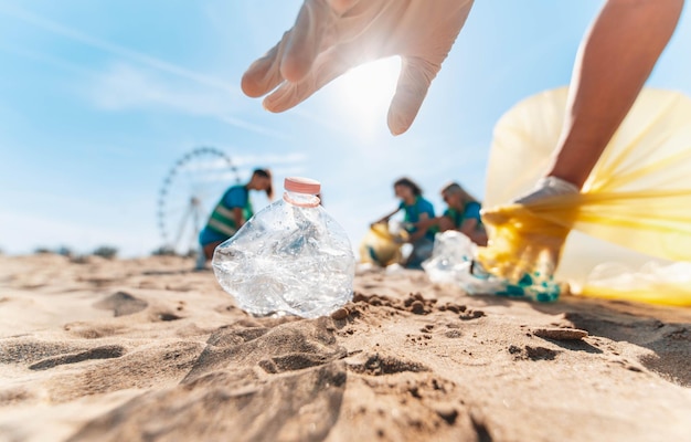 Grupa wolontariuszy ekologicznych zbierających plastikowe śmieci na plaży