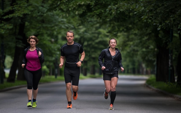 Grupa zdrowych ludzi jogging w parku miejskim, zespół biegaczy na trening rano