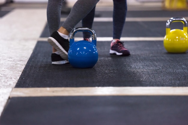 Grupa zdrowych młodych sportowców robienie ćwiczeń z kettlebells w fitness cross studio