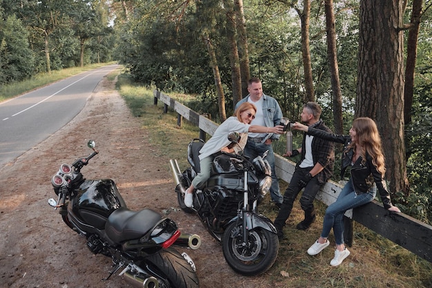 Grupa znajomych podróżuje razem na motocyklach zatrzymanych na poboczu baw się i pij herbatę