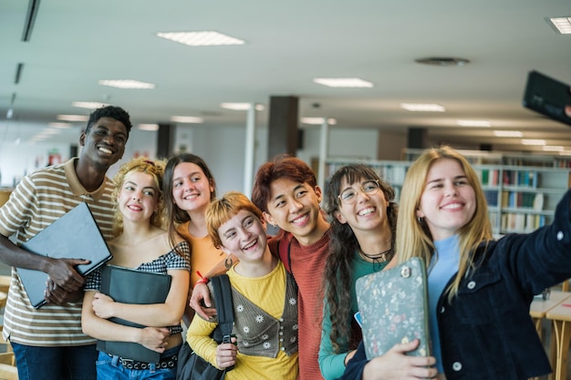 Grupowe selfie wieloetnicznych studentów w bibliotece uniwersyteckiej