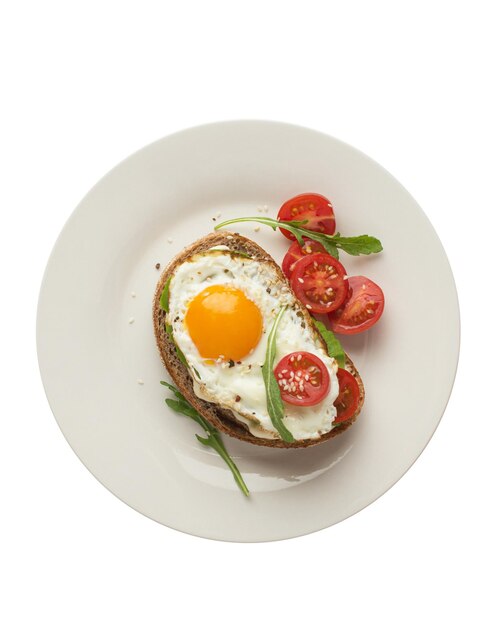 Grzanki z jajecznym awokado i innymi warzywami na szarym tle w talerzu zdrowe śniadanie