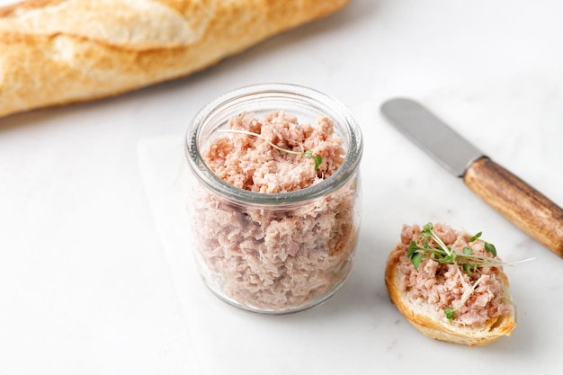 Grzanki Z Pasztetem Z Tuńczyka Lub Rillettes Na Białej Tablicy Z Bagietką Szklany Słoik Z Rybnymi Rillettes Zbliżenie