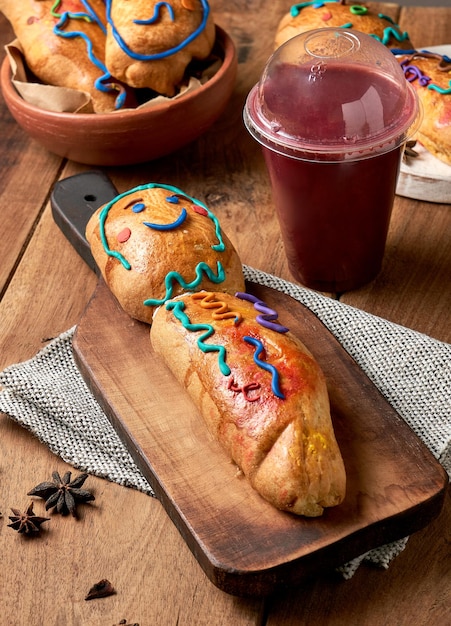 Guaguas de pan i colada morada na drewnianej podstawie, ekwadorskie figurki chleba na Dzień De