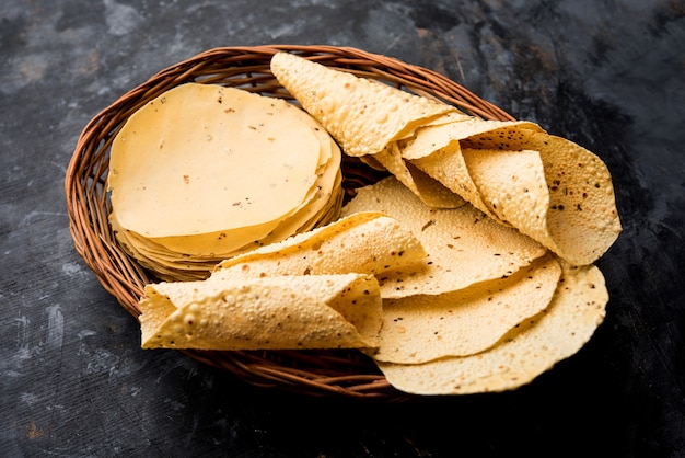 Gujarati papad lub papadum w postaci surowej suszonej z pieczonym rożkiem, bułką i odmianą płaską