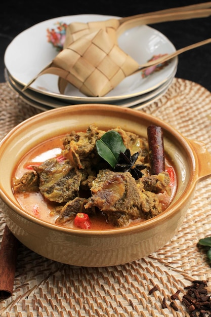 Gulai Sapi to typowo tradycyjne jedzenie wołowe curry z Padang w Zachodniej Sumatrze w Indonezji. Podawane do stołu z miską i Ketupatem Lebaranem. Menu na Id al-Adha (Idul Adha)