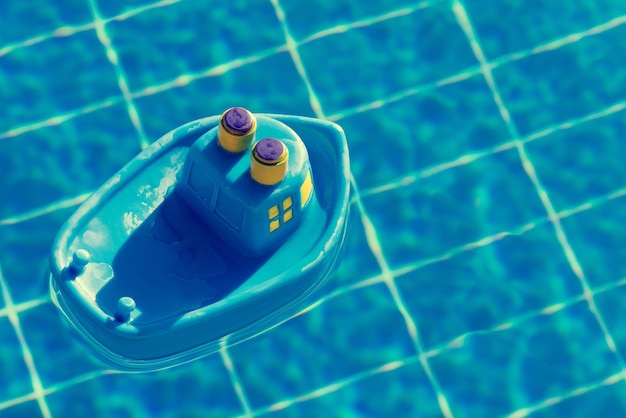 Gumowa zabawka niebieski statek unosi się w widoku basenu z góry