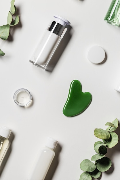 Gwasz zeskrobuje zielony jadeit i produkt kosmetyczny kremowy zdobiony eukaliptusem Masażer z kamieniami naturalnymi