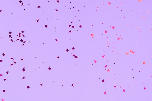 Gwiazdki fioletowe brokat konfetti w abstrakcyjnym stylu na tle mięty.
