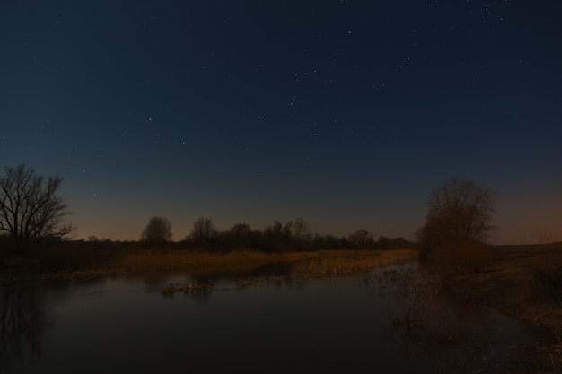 Gwiazdy na nocnym niebie nad rzeką. Wczesna wiosna w centralnej Rosji