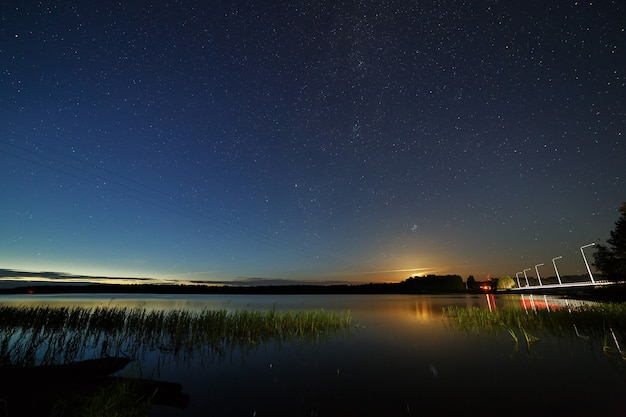 Gwiazdy na nocnym niebie nad rzeką.