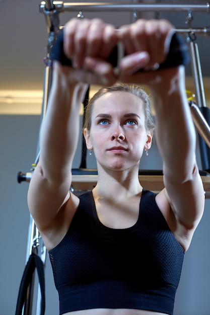 Gym Kobieta Pilates Rozciąga Sport W Reformatora łóżka Instruktora Dziewczynie.