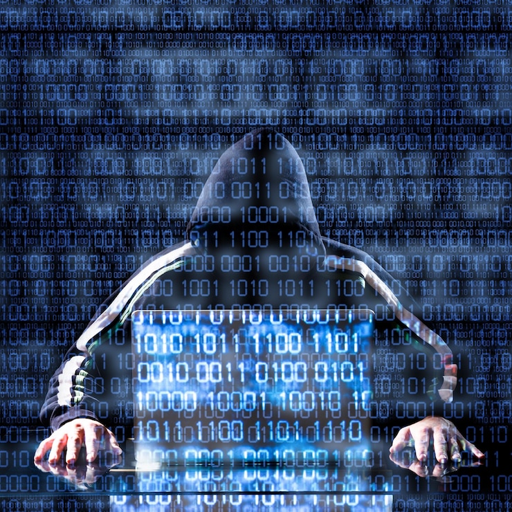 Zdjęcie hacker czekający na coś z kodem binarnym w tle