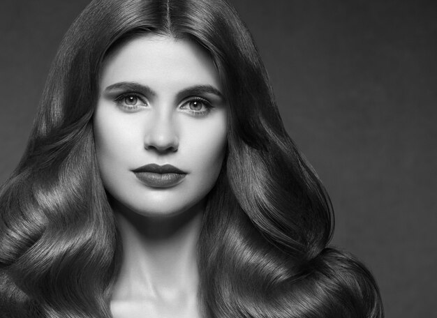 Hairte fryzura model piękna kobieta długo kręcone brunetka. Strzał studio.