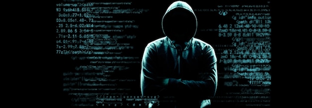 Haker drukuje kod na klawiaturze laptopa, aby włamać się do cyberprzestrzeni