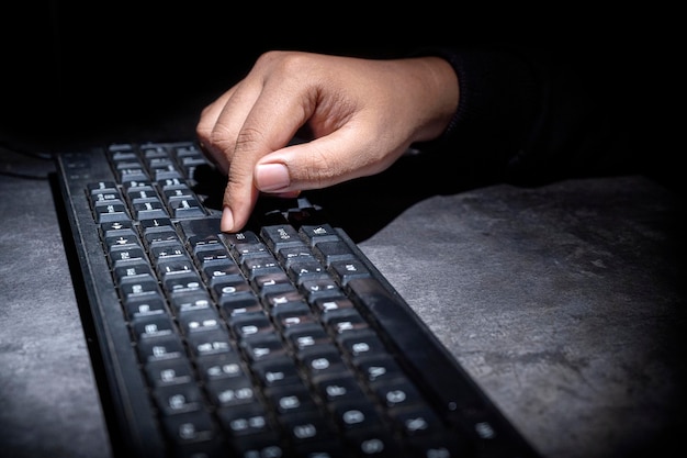 Haker ręcznie wpisuje na klawiaturze komputera Koncepcja cyberbezpieczeństwa