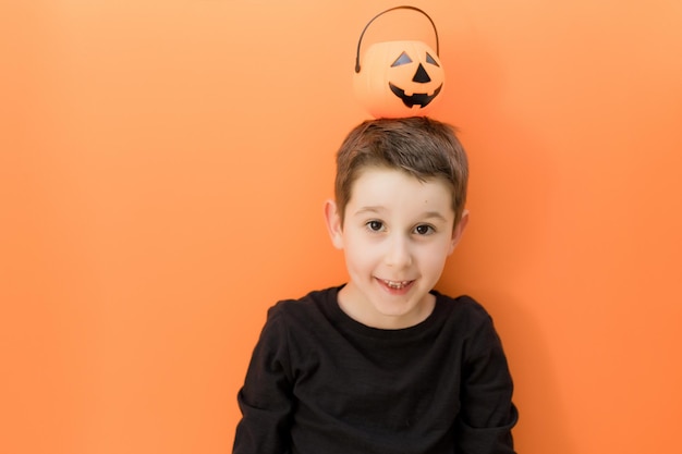 Halloween pomarańczowe tło z kaukazyjskim chłopcem