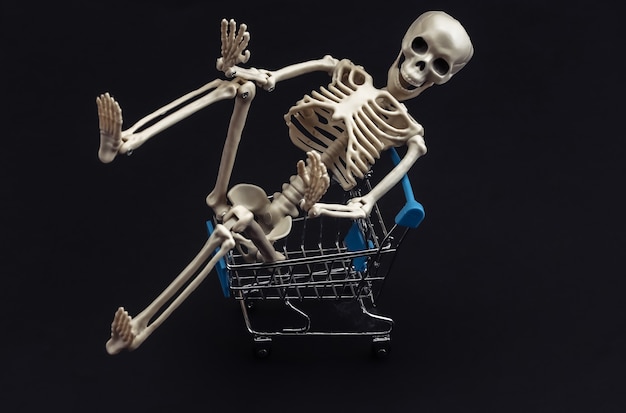 Zdjęcie halloween, przerażający motyw. szkielet i wózek na zakupy na czarno.