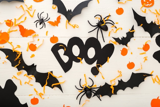 Halloween tło z jack-o'-lanter, dynie, papierowe nietoperze, pająki, konfetti na białym tle drewnianych. Dekoracje na Halloween. Płaski świeckich, widok z góry. Makieta zaproszenia na przyjęcie, uroczystość.