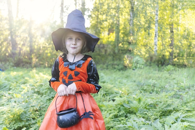 Halloweenowa urocza dziewczyna zamierza zbierać cukierkową sztuczkę lub leczyć przebrany Jack o lantern świętuje