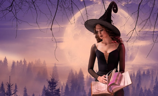 Halloweenowa Wiedźma Piękna Młoda Kobieta W Kapeluszu Wiedźmy Przywołuje Praktyki Czarów Ze Starą Książką W Dłoniach Na Tle Ogromnego Liliowego Księżyca Szeroki Projekt Sztuki Halloween