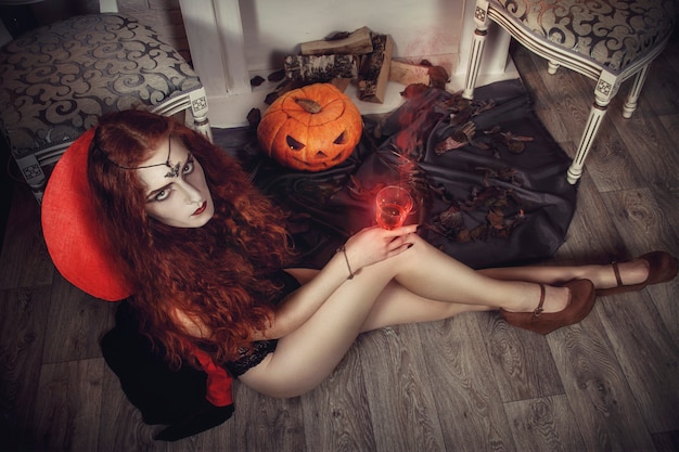 Halloweenowa Wiedźma Przygotowuje Się Do święta Zmarłych. Rudowłosa Czarodziejka. Mistyczne Czary