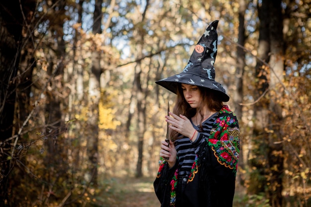 Zdjęcie halloweenowa wiedźma z nożem w lesie