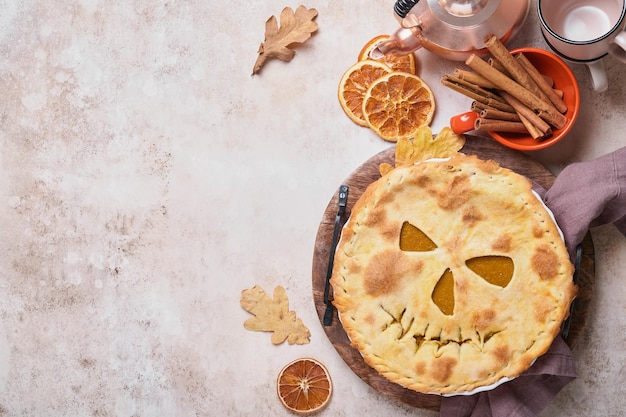 Halloweenowe jedzenie Domowe ciasto z dyni lub tarta z przerażającą twarzą na Halloween na drewnianym stole Kopiowanie miejsca Koncepcja jedzenia na Halloween