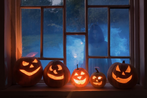 Halloweenowe Pompy Na Parapecie Z Duchem Na Zewnątrz Okna