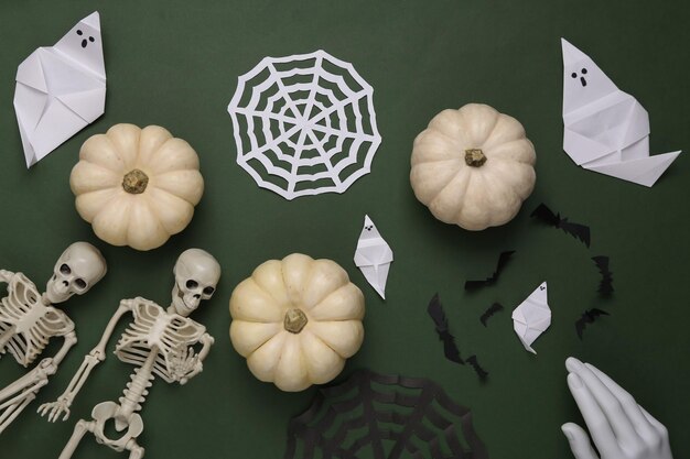 Halloweenowe ręcznie robione szkielety i dynie na zielonym tle Płaski widok z góry