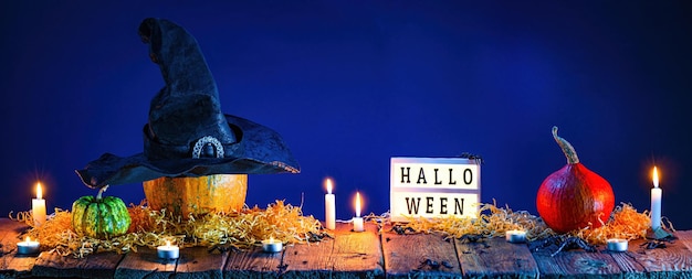 Halloweenowe tło Dynie i płonące świece na drewnianym stole