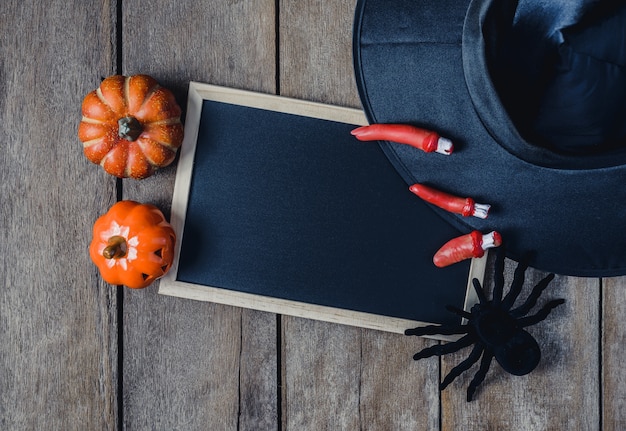 Zdjęcie halloweenowy tło z baniami, czarownica kapeluszem, czarnym pająkiem, palcami i chalkboard ,.