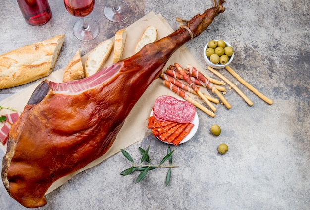 HAM JAMON SERRANO z całą nogą i winem różanym na szarym. Widok z góry. Leżał płasko